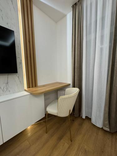 a white chair and a desk in a room at Mona Luxury Apartments - Free Garage Parking in Sarajevo