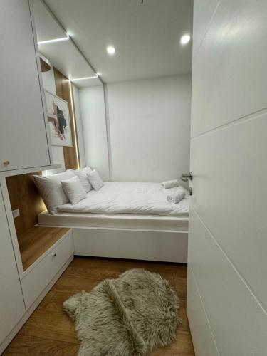 a room with a bed with a furry rug on the floor at Mona Luxury Apartments - Free Garage Parking in Sarajevo
