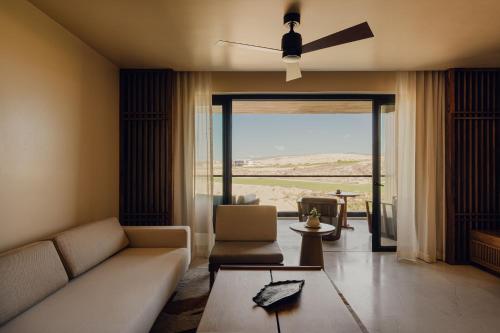 a living room with a couch and a ceiling fan at Nobu Hotel Los Cabos in Cabo San Lucas