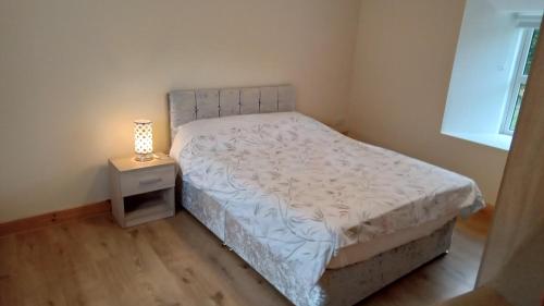 - une chambre avec un lit et une lampe sur une table de chevet dans l'établissement Boola Cottage, 