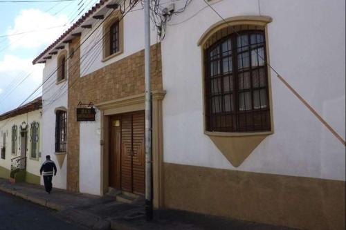 a person walking down a street next to a building at B&B SANTA CECILIA in Sucre