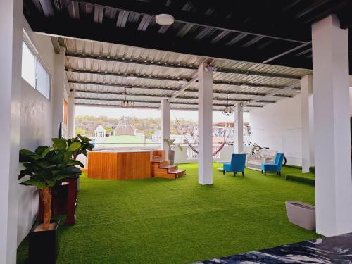 a room with green grass and a table and chairs at Suite Familiar en Puerto Ayora in Puerto Ayora