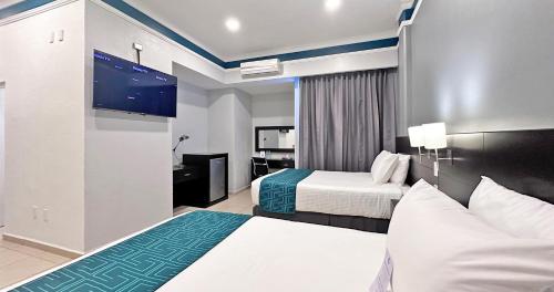 um quarto de hotel com duas camas e uma televisão de ecrã plano em InHouse León em León