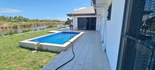 a swimming pool on the side of a house at Large 4 bedroom villa with Pool in Sonaisali Nadi in Nadi