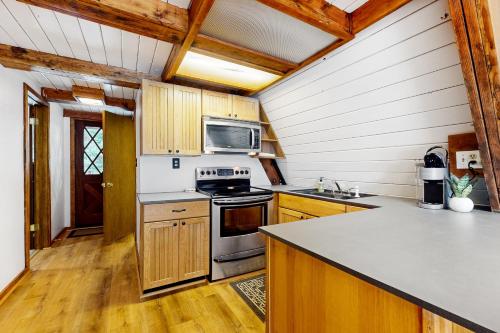 a kitchen with wooden cabinets and a stove top oven at Alpine Modern A-Frame in Snoqualmie Pass