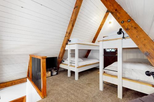 a attic room with two bunk beds and a tv at Alpine Modern A-Frame in Snoqualmie Pass