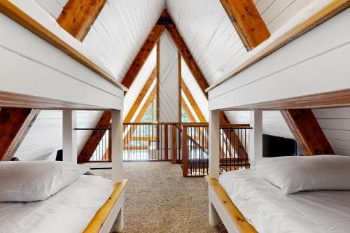 two beds in a room with wooden ceilings at Alpine Modern A-Frame in Snoqualmie Pass