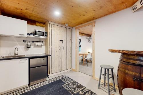 a kitchen with a counter and a stool in a room at Alpine Modern A-Frame in Snoqualmie Pass