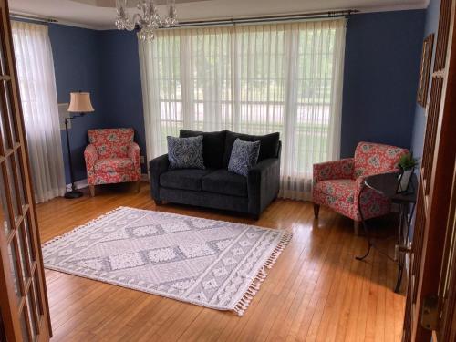 a living room with a couch and two chairs and a rug at Cozy Algoma Retreat! Minutes to Beach and Downtown! in Algoma