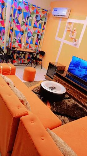 uma sala de estar com um computador portátil e uma mesa em As résidence meublée em Ouagadougou