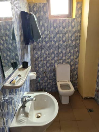 uma casa de banho com um lavatório e um WC em As résidence meublée em Ouagadougou