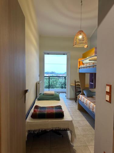 Cette chambre comprend 2 lits et une fenêtre. dans l'établissement ΔΩΜΑΤΙΟ ΜΕ ησυχία και θέα, à Patras