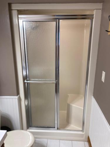 a shower with a glass door in a bathroom at Cozy Algoma Retreat! Minutes to Beach and Downtown! in Algoma