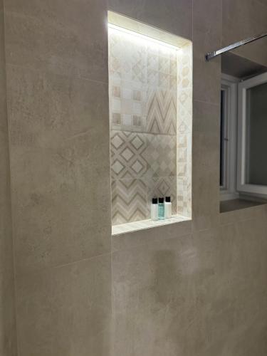 a bathroom with a shower with a tile wall at Mona Luxury Apartments - Free Garage Parking in Sarajevo