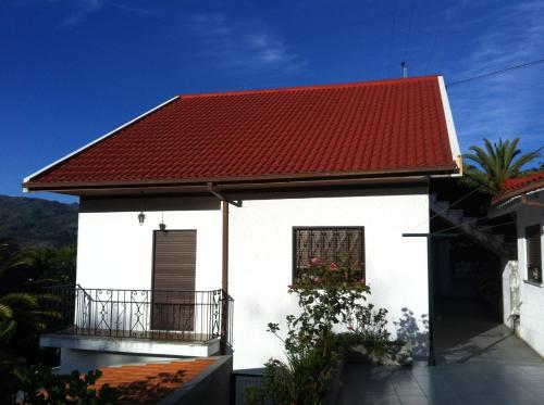 a white house with a red roof and a balcony at Casa Dos Cabecinhos in Paradamonte