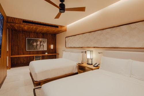 a hotel room with two beds and a ceiling fan at Nobu Hotel Los Cabos in Cabo San Lucas