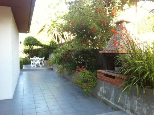 a garden with a white bench and some flowers at Casa Dos Cabecinhos in Paradamonte