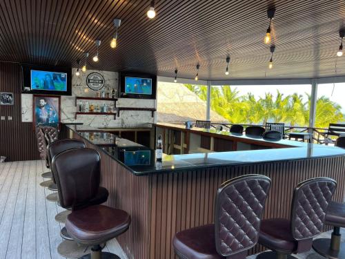 a bar in a restaurant with chairs and televisions at Captain Morgan's Retreat in San Pedro