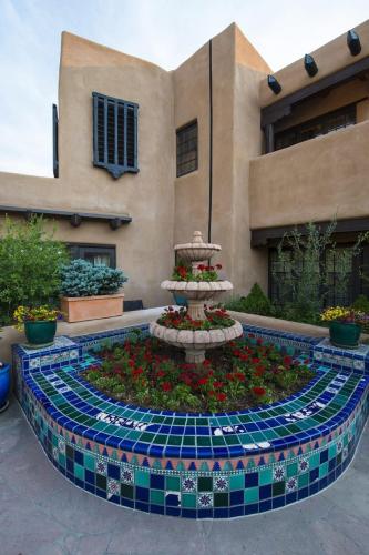 a fountain in a garden in front of a building at La Fonda on the Plaza in Santa Fe