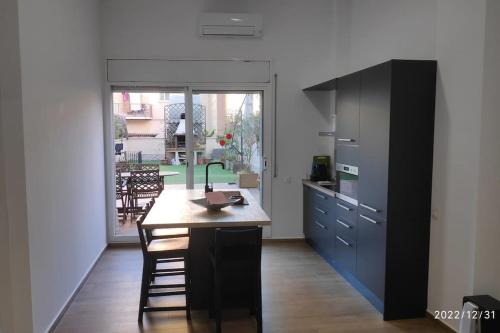 eine Küche mit einem Holztisch und einem großen Fenster in der Unterkunft Precioso apartamento con magnífico patio. in Sant Feliu de Llobregat