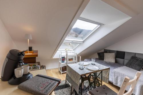 ein Wohnzimmer im Dachgeschoss mit einem Sofa und einem Tisch in der Unterkunft Sagenhafter Ausblick in Bad Peterstal-Griesbach