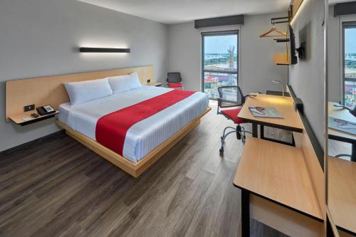 Ένα ή περισσότερα κρεβάτια σε δωμάτιο στο City Express Plus by Marriott Guadalajara Palomar