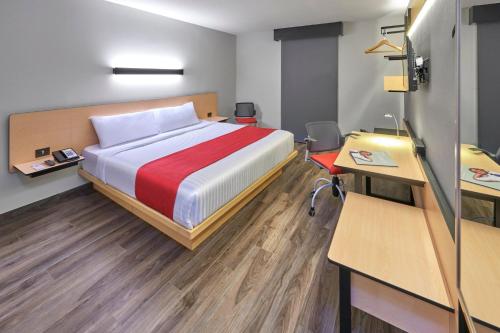 Ένα ή περισσότερα κρεβάτια σε δωμάτιο στο City Express Plus by Marriott Guadalajara Palomar