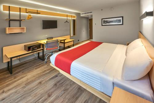 Ένα ή περισσότερα κρεβάτια σε δωμάτιο στο City Express Plus by Marriott Guadalajara Palomar
