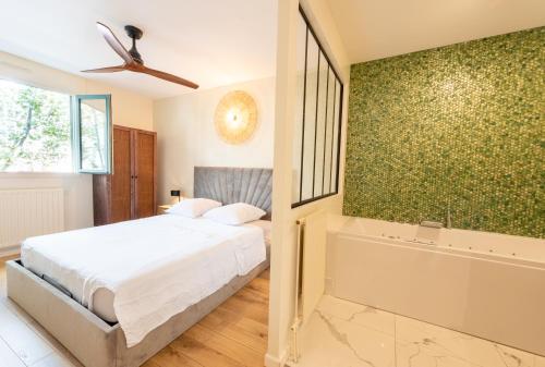 Schlafzimmer mit einem Bett und einer Badewanne in der Unterkunft LuxeZen - SPA in Villeurbanne
