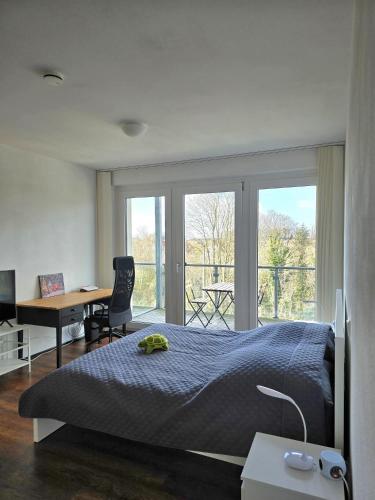 a bedroom with a bed and a desk and a window at Ferienwohnung Köln in Cologne