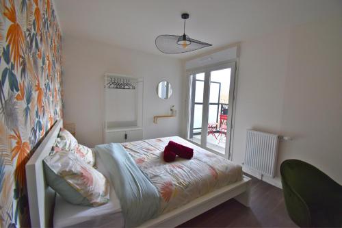 a bedroom with a bed with a red object on it at Écho Parisien in Aubervilliers