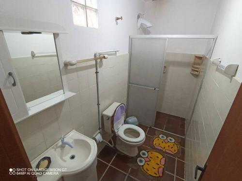 a small bathroom with a toilet and a sink at Casa de Praia em Xangri-lá a 3 quadras do mar in Xangri-lá