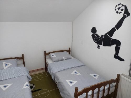 1 Schlafzimmer mit 2 Betten und einem Fußballer an der Wand in der Unterkunft Vikendica VILLA A1 in Banja Luka