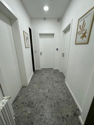 an empty hallway with white walls and concrete floors at Mona Luxury Apartments - Free Garage Parking in Sarajevo