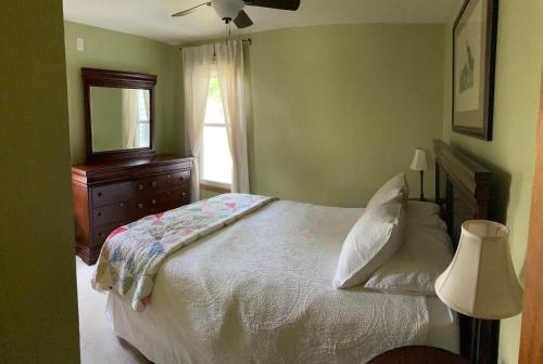 a bedroom with a bed and a dresser and a window at Cozy Algoma Retreat! Minutes to Beach and Downtown! in Algoma