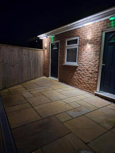 a patio in front of a brick building at night at The Woodmans Cottage in Gorfield