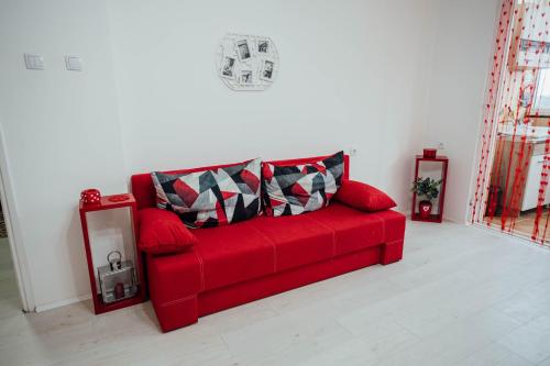a red couch sitting in a living room at Nara Apartment in Valjevo
