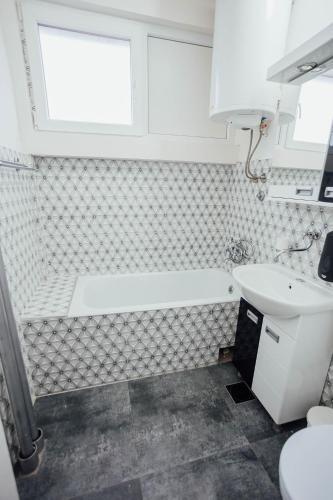 a bathroom with a bath tub and a sink at Nara Apartment in Valjevo