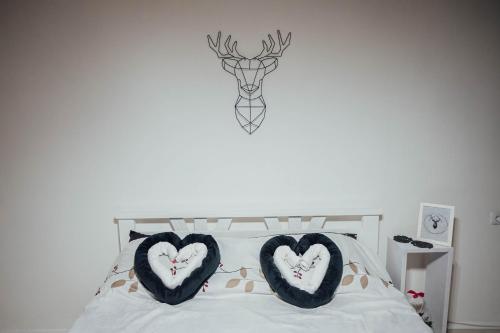 a bedroom with two heart pillows on a bed at Nara Apartment in Valjevo