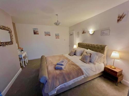 una camera da letto con un grande letto con cuscini sopra di Betty's Bungalow a Lancing