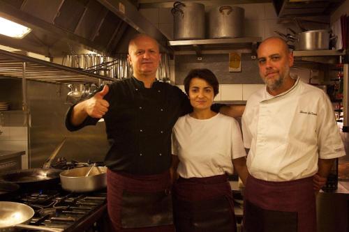 a group of three people standing in a kitchen at La Bussola Da Gino in Quarrata