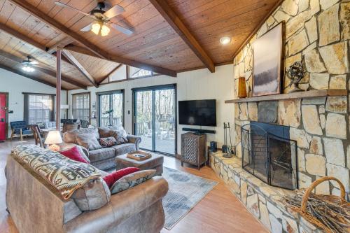 a living room with a large stone fireplace at Smoky Mountain Cabin with Fire Pit and Stunning Views! in Andrews