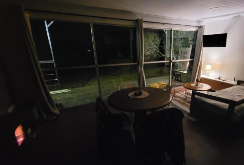 Zimmer mit einem Tisch und einem großen Fenster in der Unterkunft Casa Florida in Villa Serrana