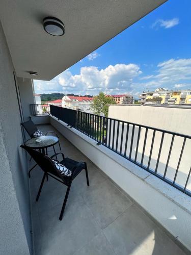 a balcony with a chair and a view of a city at LadyDi apartman in Banja Koviljača