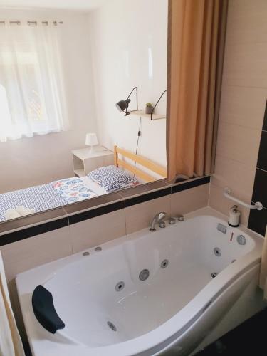 eine Badewanne im Bad mit Spiegel in der Unterkunft Apartment Sandra Toplice Sveti Martin in Sveti Martin na Muri