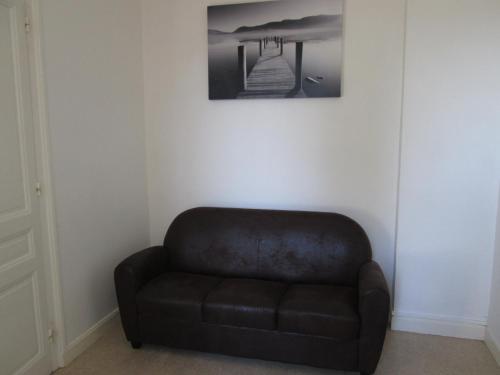a brown couch in a room with a picture on the wall at Santy. in Bron