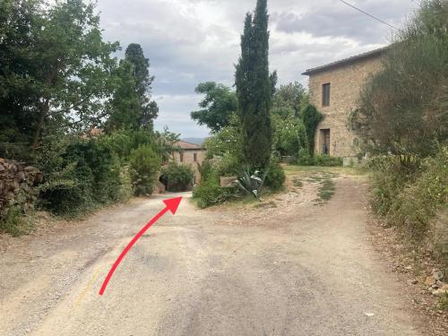 a road with a red arrow pointing to a house at Cozy room at Podere Noceto in Grotti