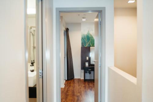 a hallway with a door leading into a room at Auckland City Hotel - Hobson St in Auckland
