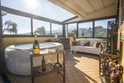 a living room with a tub and a couch at Villa Gusmano in Piedimonte Etneo