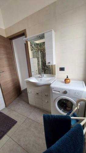 a bathroom with a washing machine and a sink at Sesto Piano Apartment in Asti